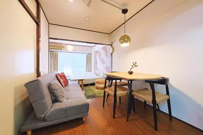a living room with a couch and a table at \u6075\u6bd4\u5bff\u99c5\u304b\u3089\u5f92\u6b691\u5206 \u6e0b\u8c373\u5206 \u65b0\u5bbf10\u5206 30m2\u3067\u3086\u3063\u305f\u308a \u6700\u9ad8\u306e\u7acb\u5730 302\u53f7\u5ba4 in Tokyo