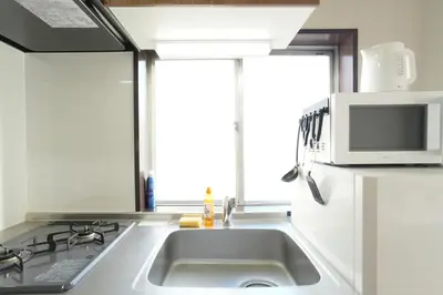a kitchen with a sink and a microwave at Asakusa 5 Chome One Bedroom KazeNoItsu 401 in Tokyo