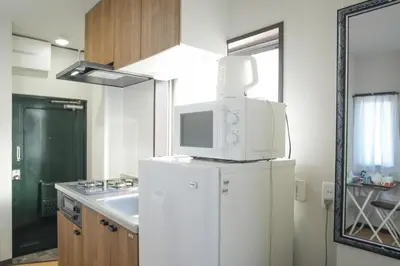 a kitchen with a microwave on top of a refrigerator at Asakusa 5 Chome One Bedroom KazeNoItsu 401 in Tokyo