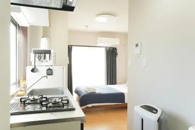 a kitchen with a stove top oven next to a bed at Asakusa 5 Chome One Bedroom KazeNoItsu 401 in Tokyo