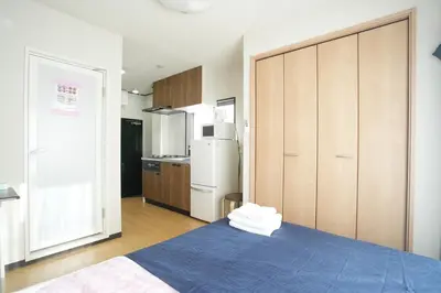 a bedroom with a blue bed and a refrigerator at Asakusa 5 Chome One Bedroom KazeNoItsu 401 in Tokyo