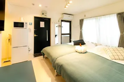 a hotel room with two beds and a refrigerator at FIKA Shibuya Honmachi 201 in Tokyo