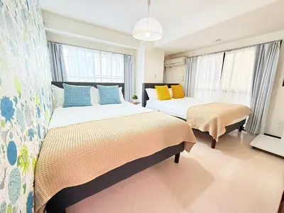 two beds in a room with two windows at Asakusa City Heim in Tokyo