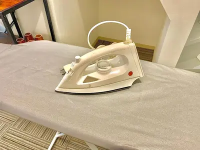 a white iron sitting on top of a bed at Luna House ASAKUSA TOKYO SKYTREE in Tokyo