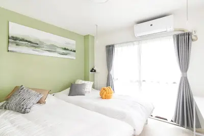 two beds in a room with a window at FIKA Shibuya Honmachi 202 in Tokyo