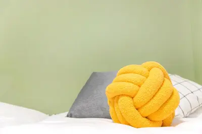 a pair of yellow towels on a bed with a pillow at FIKA Shibuya Honmachi 202 in Tokyo