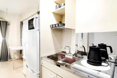 a white kitchen with a sink and a refrigerator at FIKA Shibuya Honmachi 202 in Tokyo
