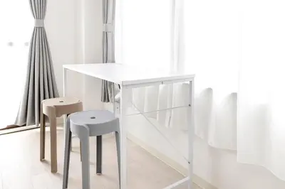 a white table and two stools in a room at FIKA Shibuya Honmachi 202 in Tokyo