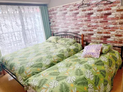 a bedroom with a bed and a brick wall at Shinjuku Kabukicho lions mansion#Shinjuku Center#2 bed rooms#\u65b0\u5bbf\u4e2d\u5fc3\u5730\u5e26 \u6b4c\u821e\u4f0e\u753a \u8f66\u7ad9\u6b65\u884c2\u5206#2\u4e2a\u5367\u5ba4\u516c\u5bd3#Autolock#\u9ad8\u901f\u65e0\u9650\u5236\u7f51\u7edc306 in Tokyo