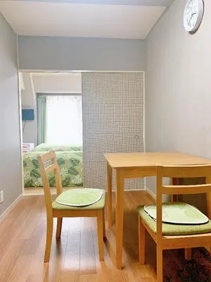 a room with a table and two chairs and a bed at Shinjuku Kabukicho lions mansion#Shinjuku Center#2 bed rooms#\u65b0\u5bbf\u4e2d\u5fc3\u5730\u5e26 \u6b4c\u821e\u4f0e\u753a \u8f66\u7ad9\u6b65\u884c2\u5206#2\u4e2a\u5367\u5ba4\u516c\u5bd3#Autolock#\u9ad8\u901f\u65e0\u9650\u5236\u7f51\u7edc306 in Tokyo