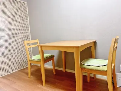 a wooden table and two chairs in a room at Shinjuku Kabukicho lions mansion#Shinjuku Center#2 bed rooms#\u65b0\u5bbf\u4e2d\u5fc3\u5730\u5e26 \u6b4c\u821e\u4f0e\u753a \u8f66\u7ad9\u6b65\u884c2\u5206#2\u4e2a\u5367\u5ba4\u516c\u5bd3#Autolock#\u9ad8\u901f\u65e0\u9650\u5236\u7f51\u7edc306 in Tokyo