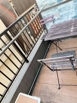 a bench and a picnic table on a balcony at Shinjuku Kabukicho lions mansion#Shinjuku Center#2 bed rooms#\u65b0\u5bbf\u4e2d\u5fc3\u5730\u5e26 \u6b4c\u821e\u4f0e\u753a \u8f66\u7ad9\u6b65\u884c2\u5206#2\u4e2a\u5367\u5ba4\u516c\u5bd3#Autolock#\u9ad8\u901f\u65e0\u9650\u5236\u7f51\u7edc306 in Tokyo