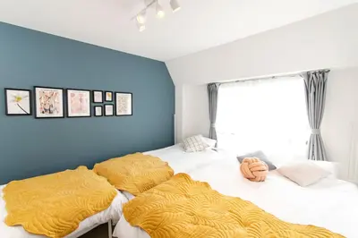 two beds in a bedroom with blue walls at FIKA Shibuya Honmachi 301 in Tokyo
