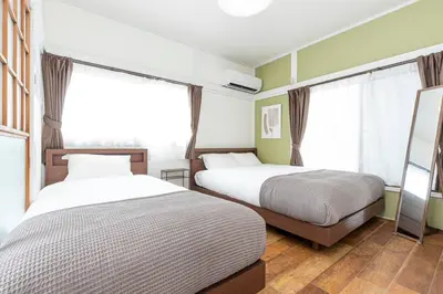two beds in a room with green walls and windows at Ohanajaya 3min Garden View House 4 beds in Tokyo