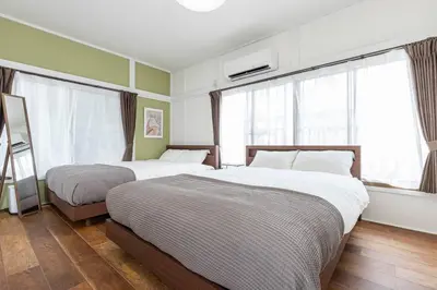 two beds in a room with green walls and windows at Ohanajaya 3min Garden View House 4 beds in Tokyo