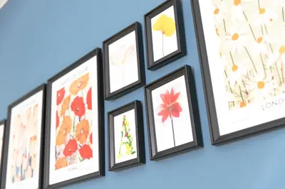 a group of framed pictures on a wall at FIKA Shibuya Honmachi Entire building in Tokyo