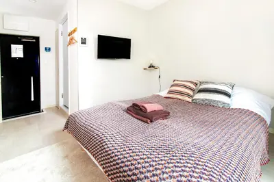 a bedroom with a bed with a tv on the wall at FIKA Shibuya Honmachi Entire building in Tokyo