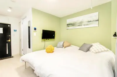 a bedroom with a white bed with a stuffed animal on it at FIKA Shibuya Honmachi Entire building in Tokyo