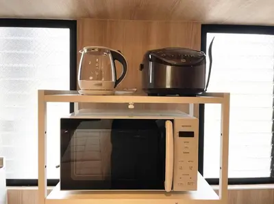 a microwave with a shelf on top of it at Yamato Residence Katsushika,10min toAsakusa Japanese style 1LDK Max10ppl in Tokyo