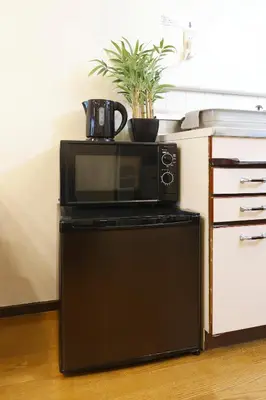 a black microwave sitting on top of a kitchen at \u6075\u6bd4\u5bff\u99c5\u304b\u3089\u5f92\u6b691\u5206 \u6e0b\u8c373\u5206 \u65b0\u5bbf10\u5206 30m2\u3067\u3086\u3063\u305f\u308a \u6700\u9ad8\u306e\u7acb\u5730 402\u53f7\u5ba4 in Tokyo