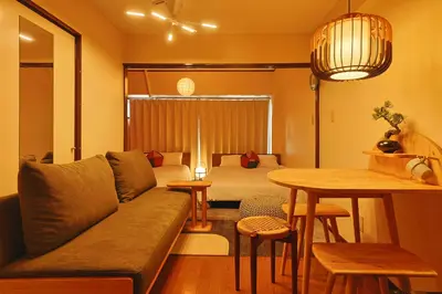 a living room with a couch and a bed and a table at \u6075\u6bd4\u5bff\u99c5\u304b\u3089\u5f92\u6b691\u5206 \u6e0b\u8c373\u5206 \u65b0\u5bbf10\u5206 30m2\u3067\u3086\u3063\u305f\u308a \u6700\u9ad8\u306e\u7acb\u5730 402\u53f7\u5ba4 in Tokyo