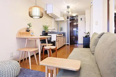 a living room with a couch and a table at \u6075\u6bd4\u5bff\u99c5\u304b\u3089\u5f92\u6b691\u5206 \u6e0b\u8c373\u5206 \u65b0\u5bbf10\u5206 30m2\u3067\u3086\u3063\u305f\u308a \u6700\u9ad8\u306e\u7acb\u5730 402\u53f7\u5ba4 in Tokyo