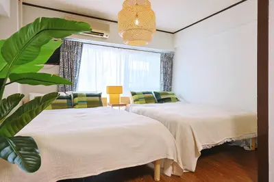 a bedroom with two beds and a plant at \u6075\u6bd4\u5bff\u99c5\u304b\u3089\u5f92\u6b691\u5206 \u6e0b\u8c373\u5206 \u65b0\u5bbf10\u5206 30m2\u3067\u3086\u3063\u305f\u308a \u6700\u9ad8\u306e\u7acb\u5730 403\u53f7\u5ba4 in Tokyo