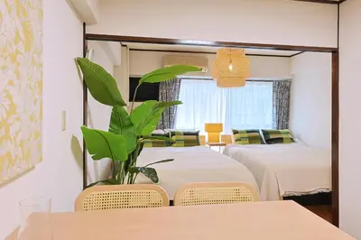 a room with two beds and a table with a plant at \u6075\u6bd4\u5bff\u99c5\u304b\u3089\u5f92\u6b691\u5206 \u6e0b\u8c373\u5206 \u65b0\u5bbf10\u5206 30m2\u3067\u3086\u3063\u305f\u308a \u6700\u9ad8\u306e\u7acb\u5730 403\u53f7\u5ba4 in Tokyo