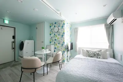 a bedroom with a bed and a table and chairs at \u30b9\u30ab\u30a4\u30d5\u30a3\u30fc\u30eb\u5927\u4e45\u4fdd in Tokyo