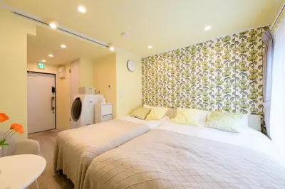 a bedroom with a large bed and a wall with at \u30b9\u30ab\u30a4\u30d5\u30a3\u30fc\u30eb\u5927\u4e45\u4fdd in Tokyo