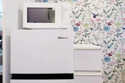a microwave sitting on top of a refrigerator in a room at \u30b9\u30ab\u30a4\u30d5\u30a3\u30fc\u30eb\u5927\u4e45\u4fdd in Tokyo