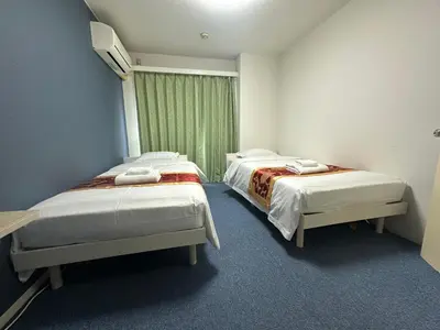 two beds in a room with a window at Akabane Apart ment Wei hefuyan7190 in Tokyo