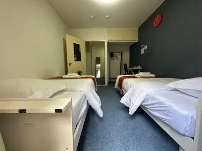 a hotel room with two beds and a mirror at Akabane Apart ment Wei hefuyan7190 in Tokyo