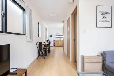 a living room with a couch and a table and chairs at \u6771\u5411\u5cf66\u4e01\u76ee in Tokyo