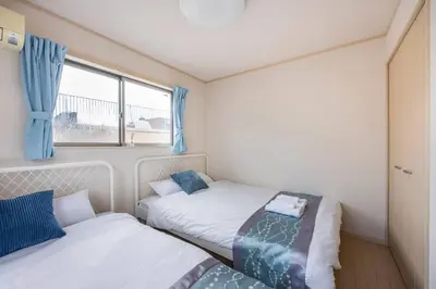 two beds in a small room with a window at \u5927\u5cf67\u4e01\u76ee in Tokyo