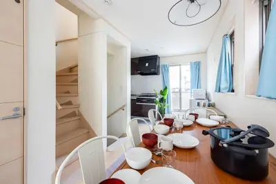 a dining room with a table and chairs and a kitchen at \u5927\u5cf67\u4e01\u76ee in Tokyo