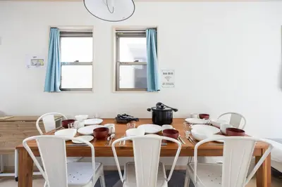 a dining room with a wooden table and white chairs at \u5927\u5cf67\u4e01\u76ee in Tokyo
