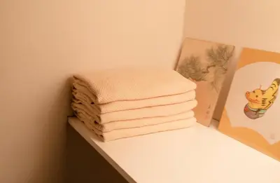 a stack of towels on a shelf next to a book at \u9ce5\u8d8a\u4e00\u6237\u5efa in Tokyo