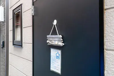 a blue door with a sign on the side of a building at \u9ce5\u8d8a\u4e00\u6237\u5efa in Tokyo