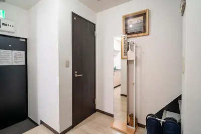 a hallway with a black door and a kitchen at \u9ce5\u8d8a\u4e00\u6237\u5efa in Tokyo