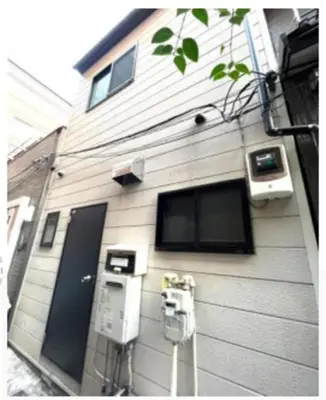 a building with two parking meters in front of it at \u9ce5\u8d8a\u4e00\u6237\u5efa in Tokyo