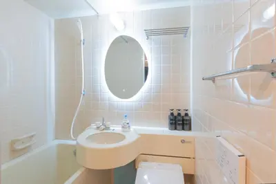 a bathroom with a sink and a toilet and a mirror at Minutes from Sumiyoshi & Iconic Attractions & Sky Tree in Tokyo