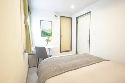 a bedroom with a bed and a table with a chair at Minutes from Sumiyoshi & Iconic Attractions & Sky Tree in Tokyo