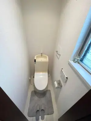a bathroom with a toilet with a slippers on the floor at Crown\u6d77\u8fba in Tokyo