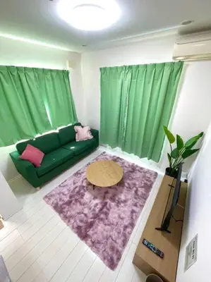 a living room with a green couch and a table at Crown\u6d77\u8fba in Tokyo