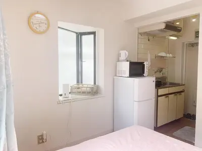 a kitchen with a white refrigerator and a clock on the wall at Shinjuku Area#Nishi-Shinjuku Gochome subway 6 minutes walk#\u9ad8\u901f\u65e0\u9650\u5236\u7f51\u7edc#\u897f\u65b0\u5bbf\u4e94\u4e01\u76ee\u8f66\u7ad9\u6b65\u884c6\u5206\u949f#211 in Tokyo