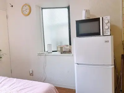 a microwave on top of a refrigerator in a room at Shinjuku Area#Nishi-Shinjuku Gochome subway 6 minutes walk#\u9ad8\u901f\u65e0\u9650\u5236\u7f51\u7edc#\u897f\u65b0\u5bbf\u4e94\u4e01\u76ee\u8f66\u7ad9\u6b65\u884c6\u5206\u949f#211 in Tokyo