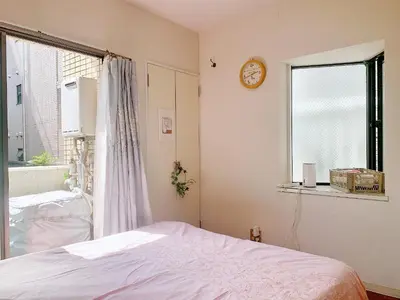a bedroom with a bed and a clock on the wall at Shinjuku Area#Nishi-Shinjuku Gochome subway 6 minutes walk#\u9ad8\u901f\u65e0\u9650\u5236\u7f51\u7edc#\u897f\u65b0\u5bbf\u4e94\u4e01\u76ee\u8f66\u7ad9\u6b65\u884c6\u5206\u949f#211 in Tokyo