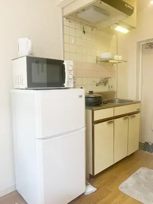 a kitchen with a microwave on top of a refrigerator at Shinjuku Area#Nishi-Shinjuku Gochome subway 6 minutes walk#\u9ad8\u901f\u65e0\u9650\u5236\u7f51\u7edc#\u897f\u65b0\u5bbf\u4e94\u4e01\u76ee\u8f66\u7ad9\u6b65\u884c6\u5206\u949f#211 in Tokyo