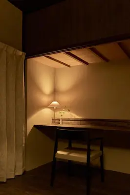 a room with a table with a chair and a lamp at Rojiura in Tokyo